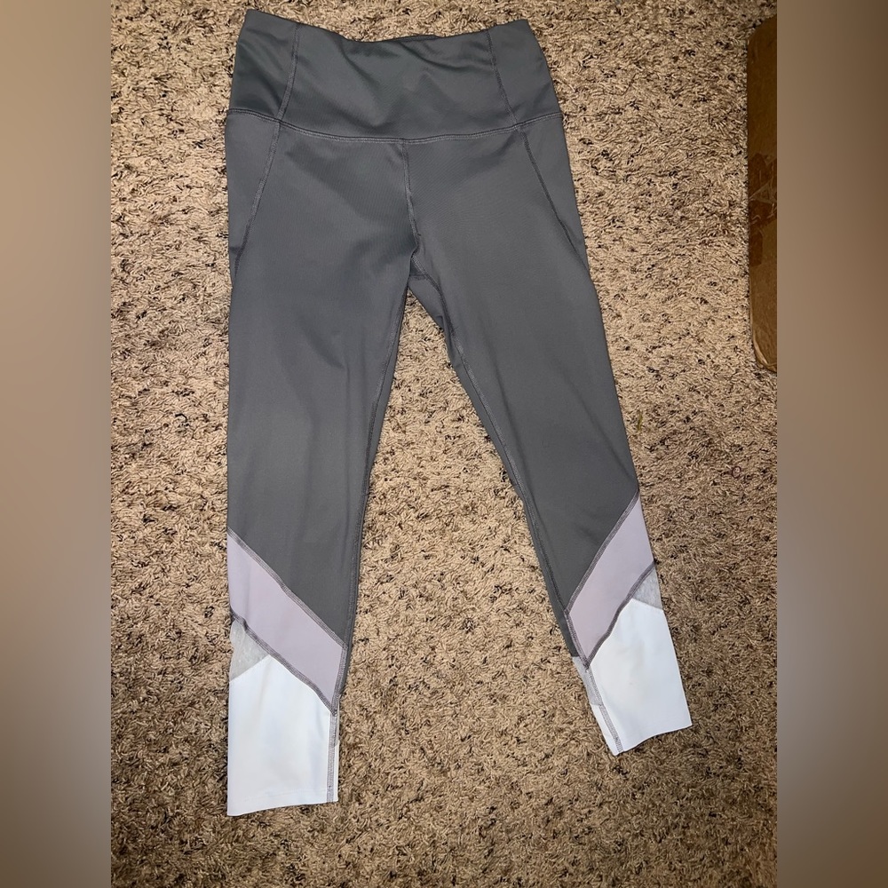 Grey clad length cut leggings with white mesh cutout.